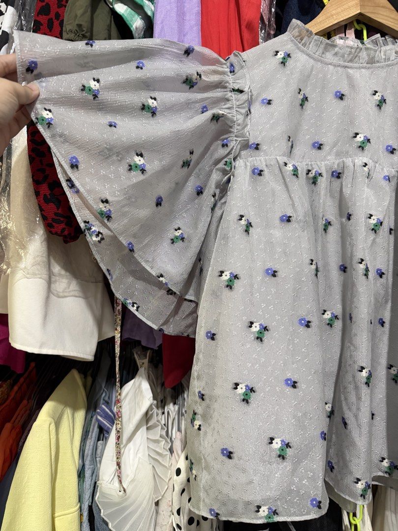Stella Nova Bluish Grey Floral Ruffle Sleeve Blouse (Category: Blouses) located in Antipolo. Submitted by harlowwillow (Listing ID 1463568067, Image 2). Description: NO TO LOW BALLERS Best fit to Large-XL EU42 W 19-20” L 23” Polyester Nylon - Cute bluish grey blouse with a charming ditsy floral print. -with inner - Features delicate ruffled flutter sleeves. - Elegant high ruffled neckline. - Subtle textured fabric adds a touch of sophistication. 