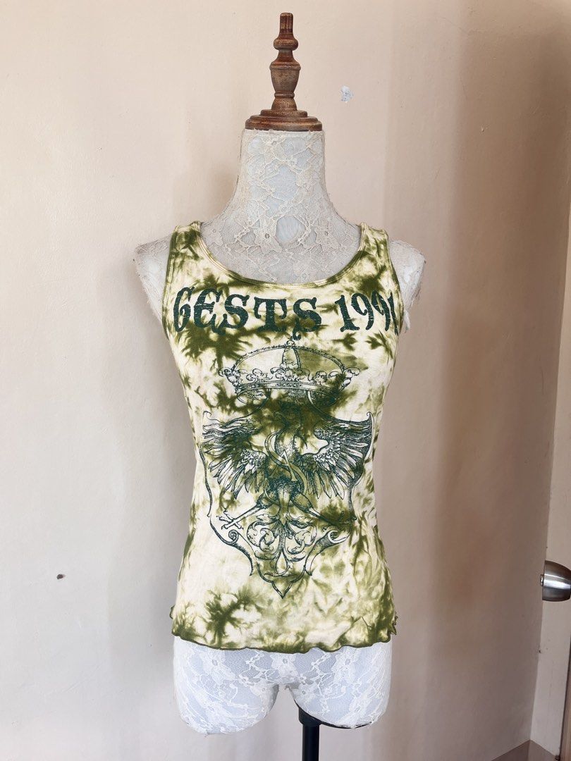Tie-dye graphic ribbed tank top (Category: Sleeveless) located in San Jose. Submitted by thymies (Listing ID 1463651232, Image 3). Description: Can fit small-med ‼️COLOR MAY VARY DUE TO LIGHTING‼️ Style: Fitted ribbed tank top / sleeveless tee Pattern & Color: Olive green and cream acid-wash / tie-dye effect Graphic: Crest coat of arms with a crowned eagle and gothic lettering (“GESTS 1991”) Aesthetic: Y2K Grunge / Alt / Vintage streetwear.