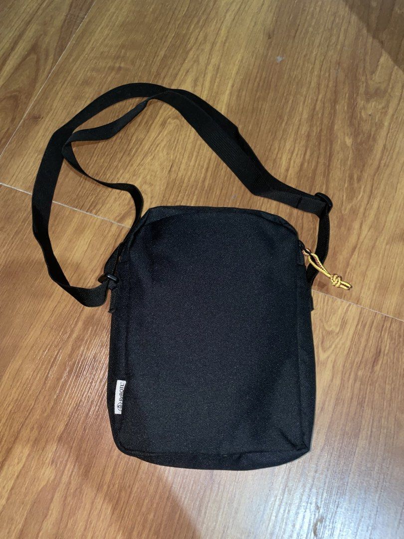 Timberland Black Crossbody Bag (Category: Sling Bags) located in Manila. Submitted by vensen1798495 (Listing ID 1463689740, Image 2). Description: - Black Timberland crossbody bag - Iconic Timberland tree logo on the front - Adjustable strap for comfortable wear - Secure zipper closure - Made in Indonesia - Ideal for everyday use - Spacious interior for essentials.