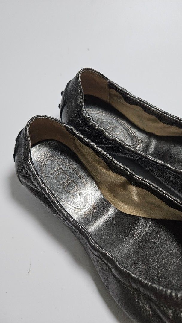 TOD'S Metallic Leather Ballet Flats (Category: Flats & Sandals) located in Alfonso. Submitted by jbcamet (Listing ID 1463677243, Image 2). Description: - TOD'S ballet flats - Metallic pewter color - Made from soft leather - Iconic rubber pebble sole - Small buckle detail on strap - Size 35.5 - Ideal for everyday wear.