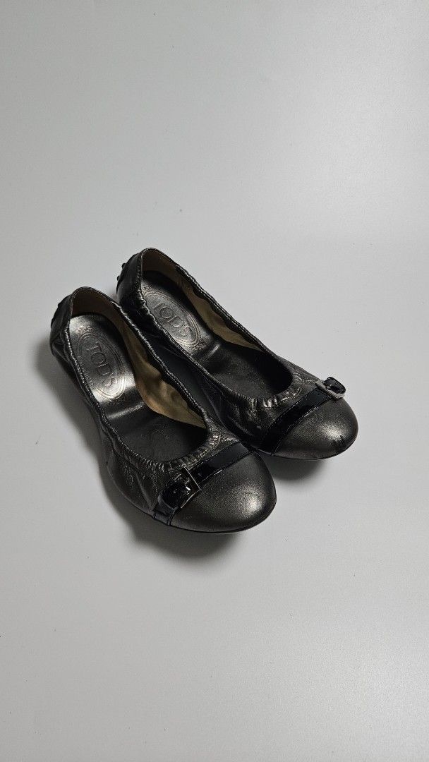 TOD'S Metallic Leather Ballet Flats (Category: Flats & Sandals) located in Alfonso. Submitted by jbcamet (Listing ID 1463677243, Image 1). Description: - TOD'S ballet flats - Metallic pewter color - Made from soft leather - Iconic rubber pebble sole - Small buckle detail on strap - Size 35.5 - Ideal for everyday wear.