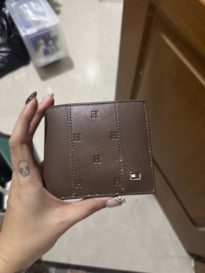 Tommy Hilfiger Brown Leather Bifold Wallet (Category: Wallets & Card Holders) located in Mandaluyong City. Submitted by prelovedbytim (Listing ID 1463675783, Image 1). Description: - Genuine Tommy Hilfiger brown leather bifold wallet. - Multiple card slots for organization. - Textured exterior with embossed 'H' logos. - Signature small Tommy Hilfiger flag logo on the front. - Ideal for everyday carry. Di po nagamit natambak lang.