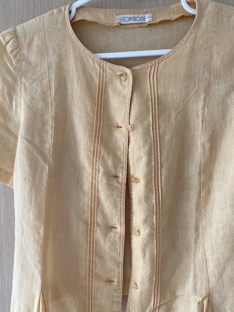 TOMROSE Yellow Button-Up Short Sleeve Blouse (Category: Blouses) located in Manila. Submitted by shopcommonlabel (Listing ID 1463602827, Image 2). Description: - Brand: TOMROSE - Color: Yellow - Style: Short sleeve blouse - Features: Button-up front, decorative pleats, round neckline, slight puff sleeves, pleated hem detail - Occasion: Versatile for casual wear or dressing up.