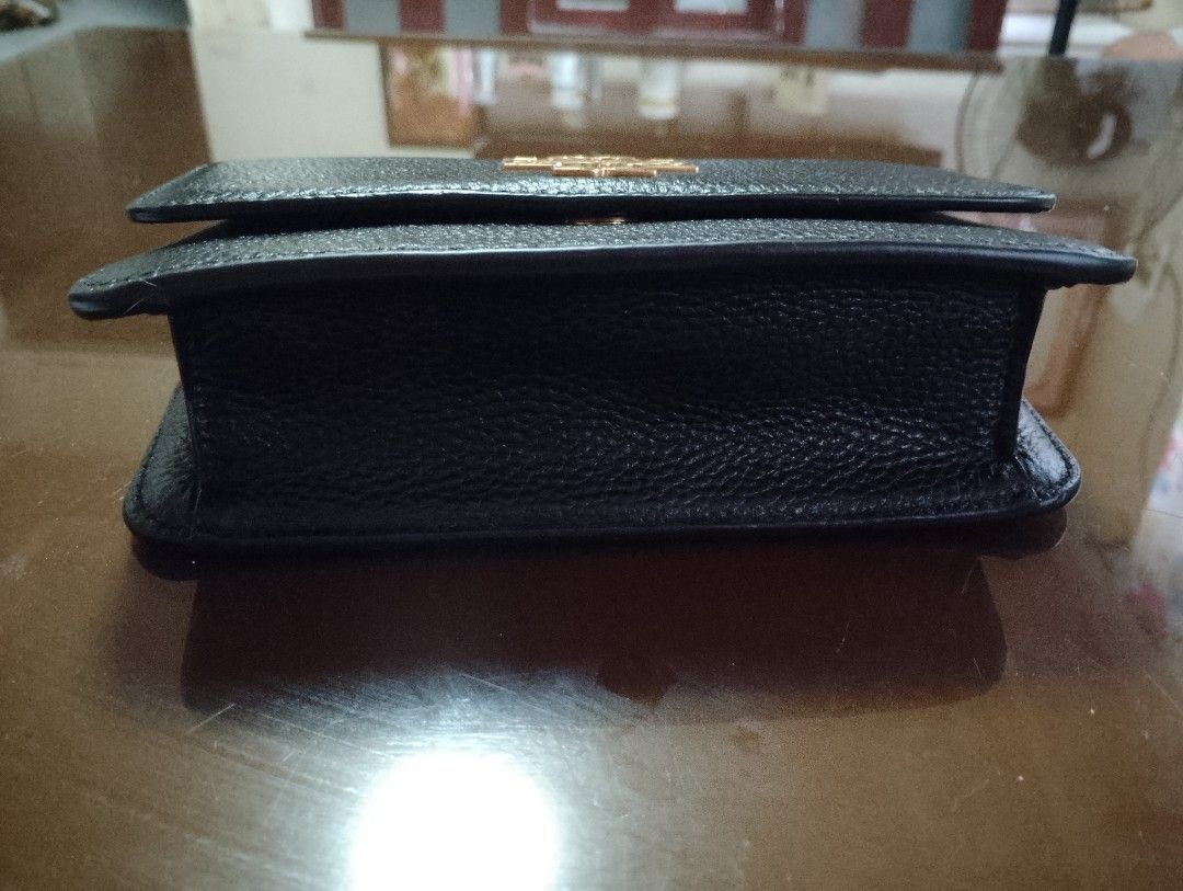 Tory Burch Black Leather Handbag with Gold Chain (Category: Luxury Bags & Wallets) located in Bacolor. Submitted by pinktintmine (Listing ID 1463639550, Image 2). Description: - Authentic Tory Burch black leather handbag - Signature gold logo on the front - Top handle and detachable gold chain strap with leather accents - Secure magnetic snap closure - Interior features Tory Burch New York branding - Small and compact size, perfect for essentials