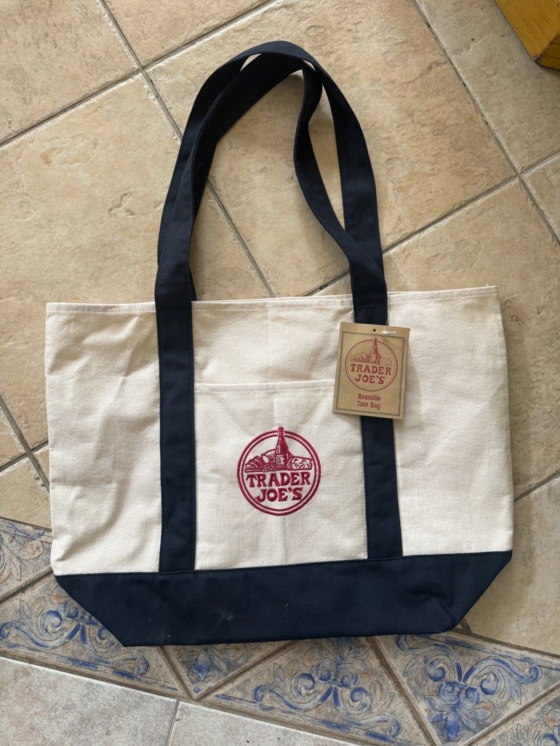 Trader Joe's Reusable Canvas Tote Bag (Category: Tote Bags) located in Taytay. Submitted by phoebspreloved (Listing ID 1463583126, Image 1). Description: - Classic Trader Joe's reusable tote bag - Iconic Trader Joe's logo embroidered in red - Ideal for groceries or everyday use - Durable and eco-friendly design.