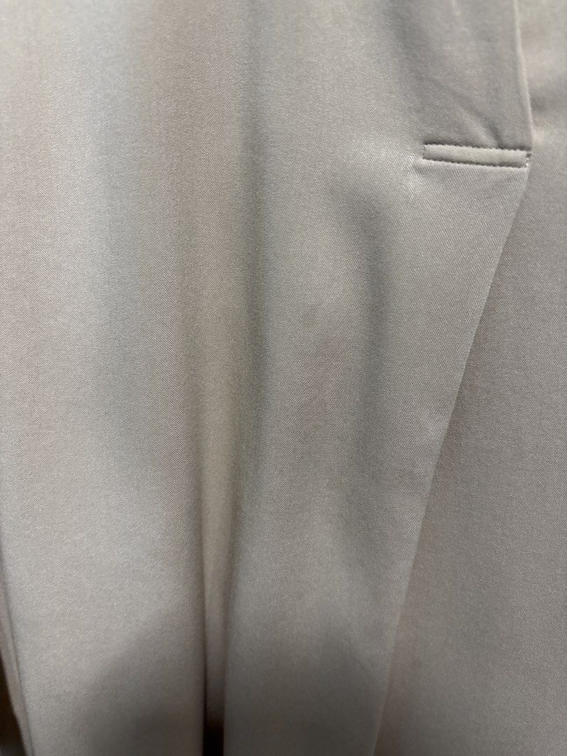 Uniqlo Beige Collared Long Sleeve Blouse Size S (With Marks) (Category: Longsleeves) located in Mandaluyong City. Submitted by clothescarousel (Listing ID 1463670192, Image 3). Description: - Uniqlo collared blouse - Beige color - Long sleeves with button cuffs - Fabric has a slight sheen - Small mark on the front (see close-up photo) - Versatile for casual or work wear.