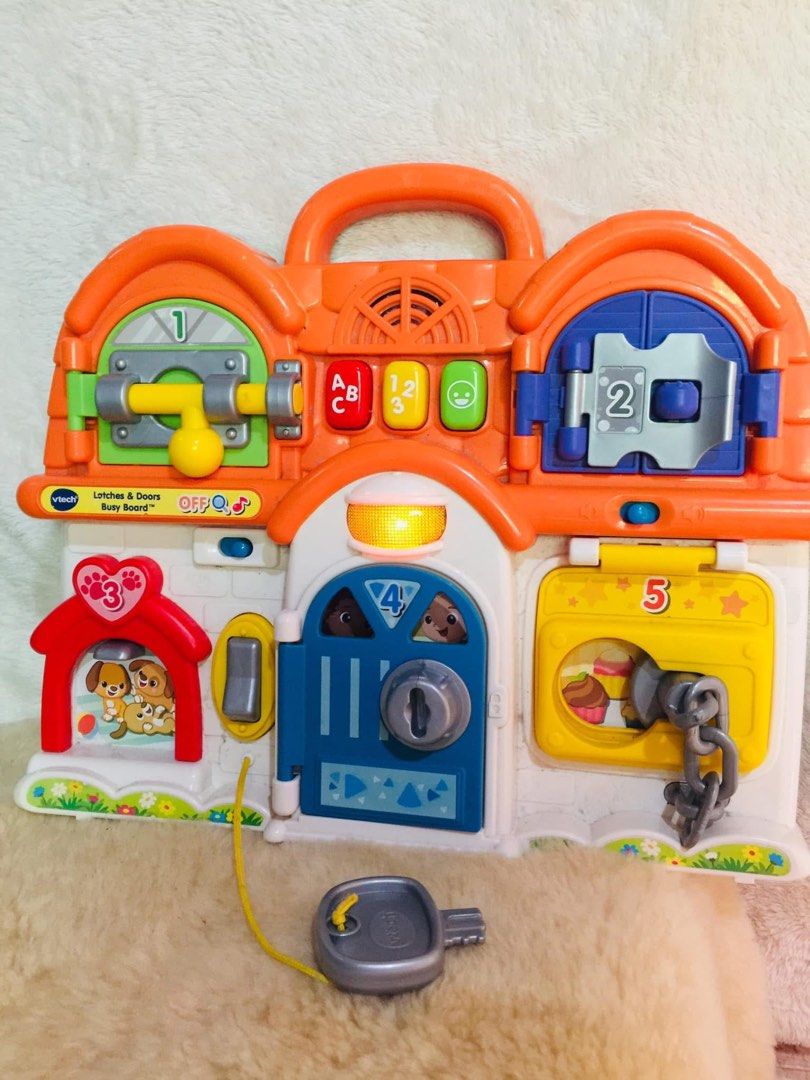 VTech Busy Board Latches & Doors Learning Toy (Category: Educational & Learning Toys) located in Baguio. Submitted by izza_thrifty (Listing ID 1463570453, Image 1). Description: - VTech Busy Board with multiple latches and doors. - Includes a key for the main door. - Bright colors and engaging sounds for interactive play. - Excellent for developing fine motor skills. - Features a handle for easy portability..