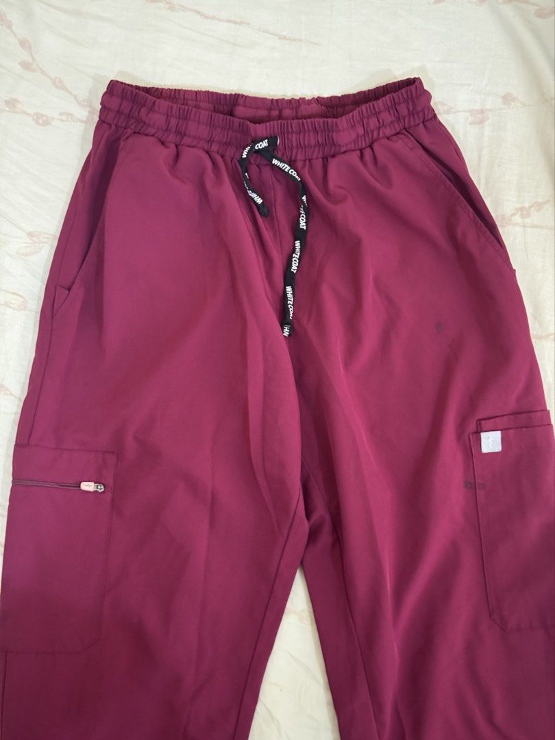 White Coat Scrub Pants Maroon / Garnet - Large (Category: Sets or Coordinates) located in Makati City. Submitted by fifoaway (Listing ID 1463708518, Image 1). Description: - Burgundy scrub pants from White Coat - Elastic waistband with drawstring - Multiple pockets, including a zippered pocket on the left leg - Small dark mark on the right thigh area - Ideal for work or lounging.