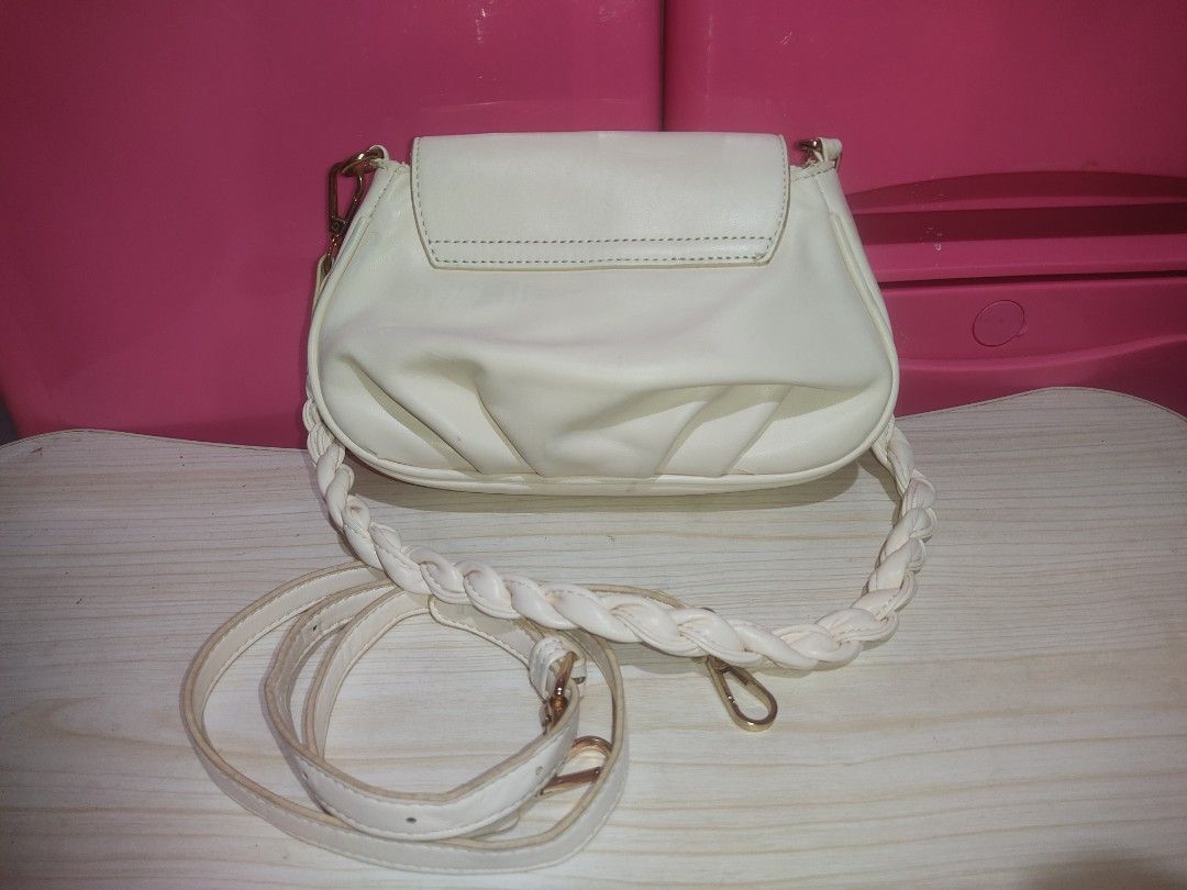 White crossbody bag with bow and braided strap (Category: Cross-body Bags) located in Manila. Submitted by xiaochao.16 (Listing ID 1463738576, Image 3). Description: - Adorable white crossbody bag - Features a sweet light pink bow on the front - Stylish braided white strap - Includes a convenient zippered pocket inside - Elegant gold hardware details - Ideal for everyday casual outings.