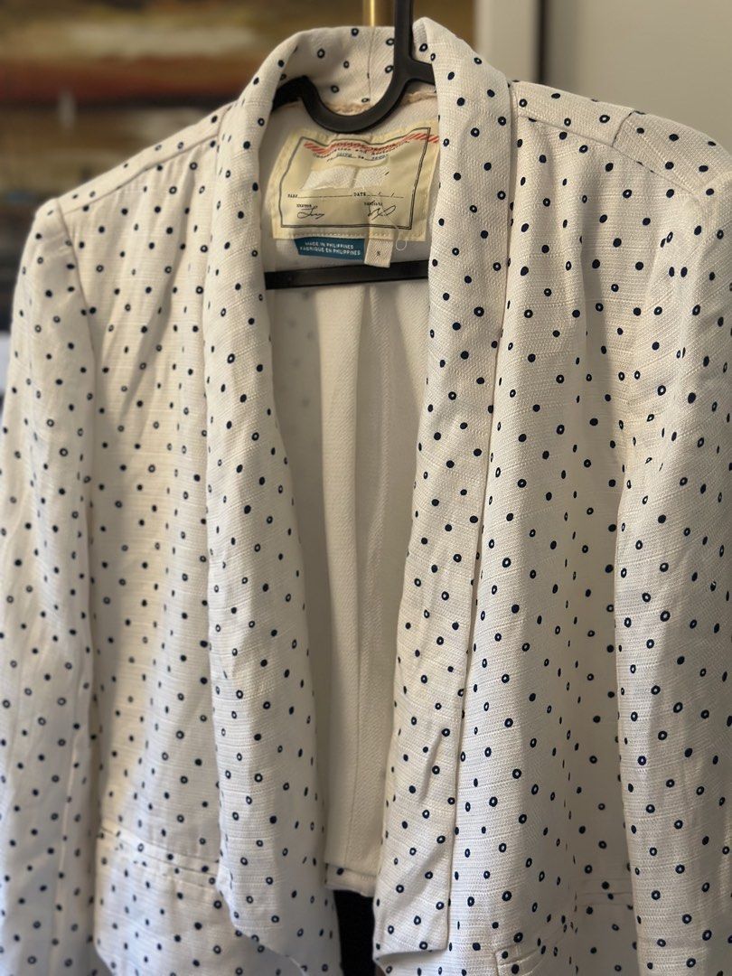 White Polka Dot Blazer Jacket (Category: Coats, Jackets and Outerwear) located in Manila. Submitted by timelessfindsbyjoann (Listing ID 1463710099, Image 2). Description: - White blazer with classic navy polka dots - Open front design with elegant draped lapel - Features functional front pockets - Versatile piece: dress up or down - Ideal for layering over tops or dresses - Proudly made in the Philippines.