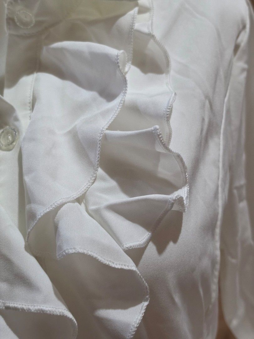 White Ruffled Blouse with Buttons (Category: Blouses) located in Malabon City. Submitted by lpzangie (Listing ID 1463706743, Image 2). Description: - White long-sleeved blouse - Size 5XL (Fit to Medium to Semi XL) - Ruffles down the front - Button closures - Decorative buttons on cuffs - Lightweight and flowy material - With Extra Button.