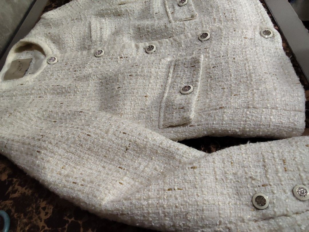 White Tweed Jacket with Silver Buttons (Category: Coats, Jackets and Outerwear) located in Manila. Submitted by chocobutternut_ (Listing ID 1463687549, Image 2). Description: - Elegant white tweed jacket with a textured weave and subtle metallic threads. - Classic round neckline with a convenient button-up front. - Two stylish flap pockets on the chest. - Functional buttons on the cuffs. - Fully lined for a comfortable fit. - Perfect for both cas