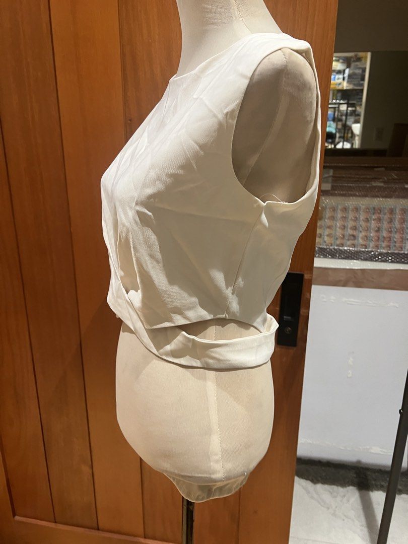 White Twist Front Sleeveless Crop Top with Zipper Back (Category: Sleeveless) located in Quezon City. Submitted by iminquezoncity (Listing ID 1463662755, Image 2). Description: - White sleeveless crop top - Features a trendy twist detail at the front - Convenient zipper closure at the back - Fabric has a subtle sheen - Best fits size Small to Medium - Perfect for dressing up or down.