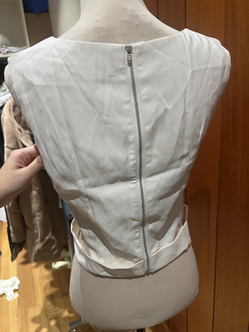 White Twist Front Sleeveless Crop Top with Zipper Back (Category: Sleeveless) located in Quezon City. Submitted by iminquezoncity (Listing ID 1463662755, Image 3). Description: - White sleeveless crop top - Features a trendy twist detail at the front - Convenient zipper closure at the back - Fabric has a subtle sheen - Best fits size Small to Medium - Perfect for dressing up or down.