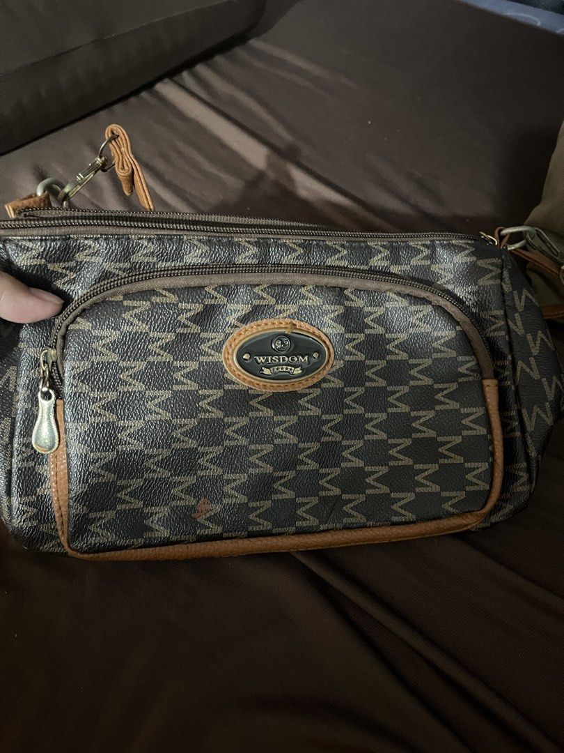 Wisdom Monogram Crossbody Bag (Category: Cross-body Bags) located in Manila. Submitted by clevercrystal_943fc9 (Listing ID 1463695682, Image 1). Description: - Chic brown and tan monogram crossbody bag - Convenient front zip pocket - Spacious main zip compartment - Elegant leather trim details - Adjustable strap for comfortable wear - Ideal for everyday adventures - Features the distinct Wisdom logo on the front.