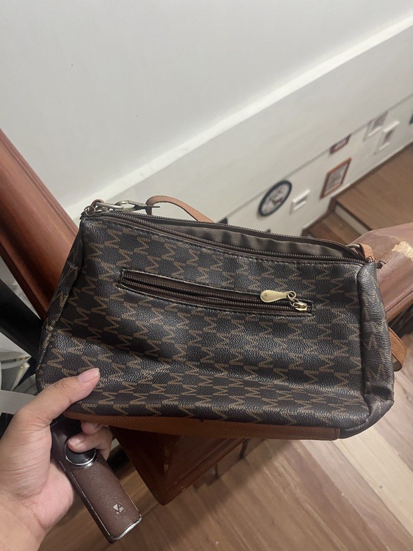 Wisdom Monogram Crossbody Bag (Category: Cross-body Bags) located in Manila. Submitted by clevercrystal_943fc9 (Listing ID 1463695682, Image 2). Description: - Chic brown and tan monogram crossbody bag - Convenient front zip pocket - Spacious main zip compartment - Elegant leather trim details - Adjustable strap for comfortable wear - Ideal for everyday adventures - Features the distinct Wisdom logo on the front.