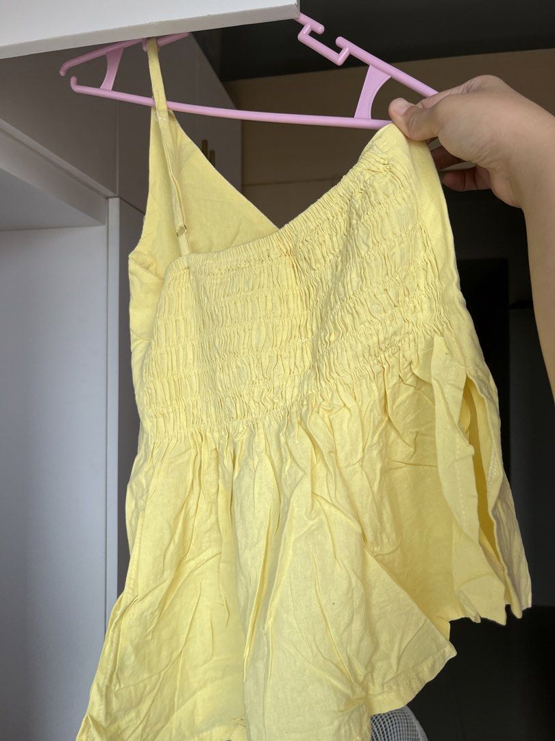 Yellow Linen One Shoulder Top (Category: Sleeveless) located in Paranaque City. Submitted by chin.declutters (Listing ID 1463644760, Image 2). Description: - Adorable yellow camisole top - Features a smocked bodice for a flattering fit - Flowy peplum hem adds a stylish flair - Adjustable spaghetti straps for customized comfort - Made from a linen or linen-blend fabric, giving it a chic texture - Versatile piece: great for casual outings or dressi