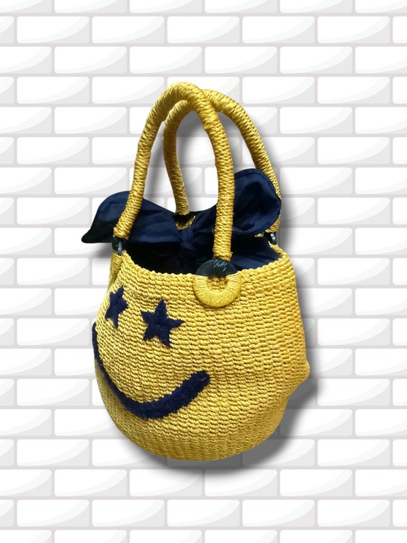 Yellow Smiley Face Straw Bag with Navy Blue Lining (Category: Shoulder Bags) located in Aguinaldo. Submitted by ukayandthrift (Listing ID 1463578257, Image 1). Description: - Adorable yellow straw bag - Features a cheerful smiley face design - Navy blue stars serve as eyes - Lined with navy blue fabric - Woven straw handles - Ideal for a fun, casual look - Perfect for carrying your essentials.