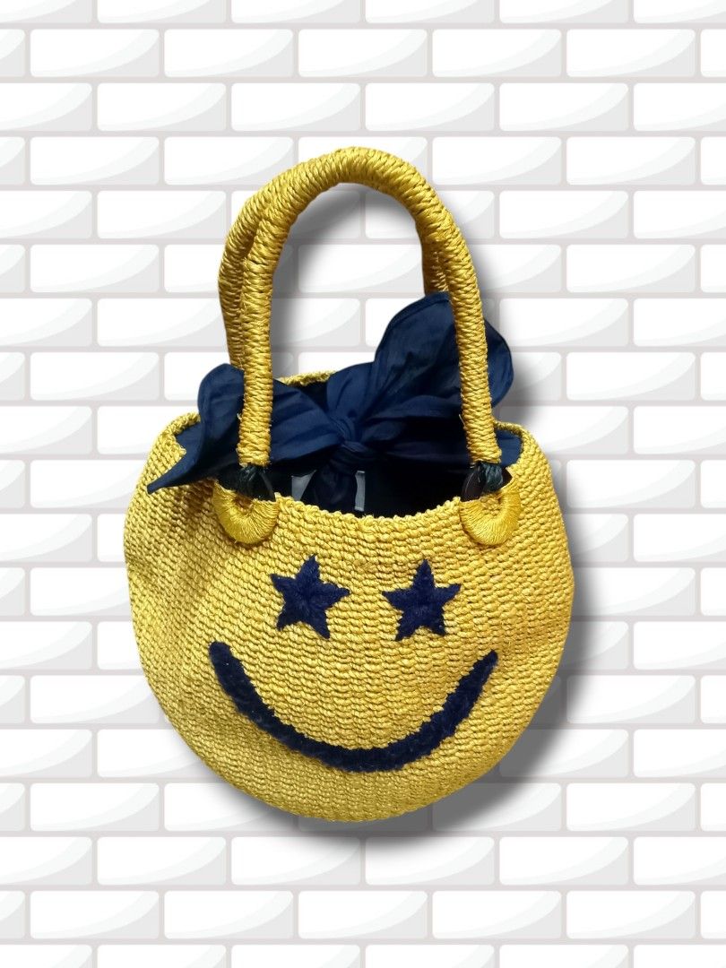 Yellow Smiley Face Straw Bag with Navy Blue Lining (Category: Shoulder Bags) located in Aguinaldo. Submitted by ukayandthrift (Listing ID 1463578257, Image 2). Description: - Adorable yellow straw bag - Features a cheerful smiley face design - Navy blue stars serve as eyes - Lined with navy blue fabric - Woven straw handles - Ideal for a fun, casual look - Perfect for carrying your essentials.