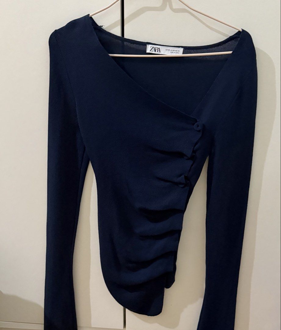 Zara Navy Blue Long Sleeve Top (Category: Longsleeves) located in Manila. Submitted by trishaaysobel (Listing ID 1463624907, Image 2). Description: - Flattering V-neck wrap neckline - Asymmetrical hemline - Ruched detailing on the side with button accents - Comfortable knit fabric - Only used twice .