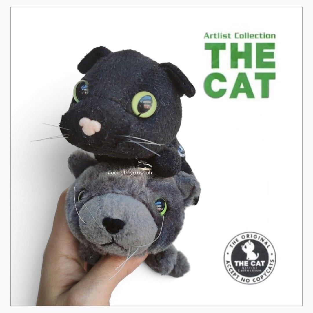 [2] THE CAT Artlist Collection (Category: Other Merchandise) located in Taguig. Submitted by adopt.my.plush.ph (Listing ID 1463882969, Image 1). Description: THE CAT Artlist Collection plush mascot bundle Featured Plush Breeds Top Plush (Black): This represents the Black Shorthair / Bombay cat variant, featuring signature oversized green glass-like eyes and a light pink nose. Bottom Plush (Gray): This represents the Russian Blue cat variant, comp