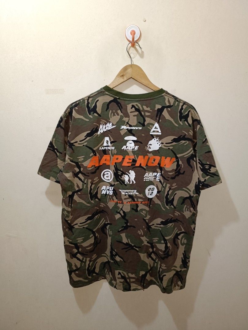 A Bathing Ape APUNVS Camo T-shirt (Category: Tshirts & Polo Shirts ) located in Makati City. Submitted by ivsseyow03 (Listing ID 1463748492, Image 2). Description: Bathing Ape APUNVS t-shirt in camouflage print. Features bold 'APUNVS' graphic across the chest and various logos on the back. Made of 100% cotton. Great piece for any streetwear collection..