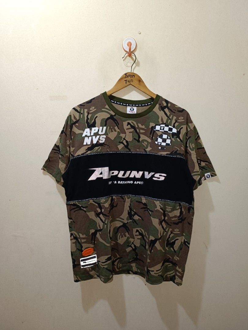 A Bathing Ape APUNVS Camo T-shirt (Category: Tshirts & Polo Shirts ) located in Makati City. Submitted by ivsseyow03 (Listing ID 1463748492, Image 1). Description: Bathing Ape APUNVS t-shirt in camouflage print. Features bold 'APUNVS' graphic across the chest and various logos on the back. Made of 100% cotton. Great piece for any streetwear collection..