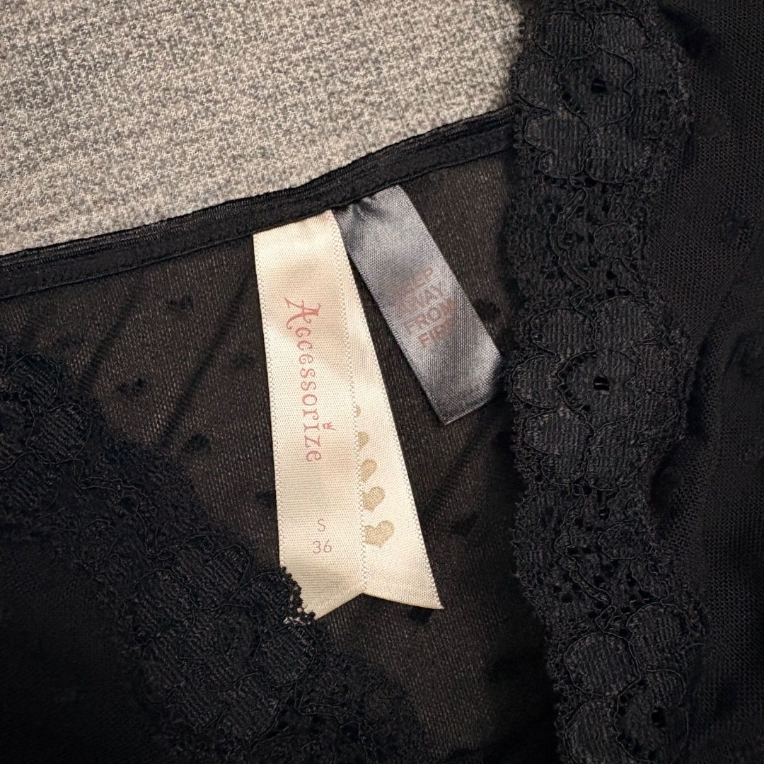 Accessorize y2k black camisole (Category: Sleeveless) located in Calamba. Submitted by bermuda.ph (Listing ID 1463881716, Image 3). Description: Featuring delicate lace trim along the v-neckline and a small decorative rose appliqué with a bow at the center.
