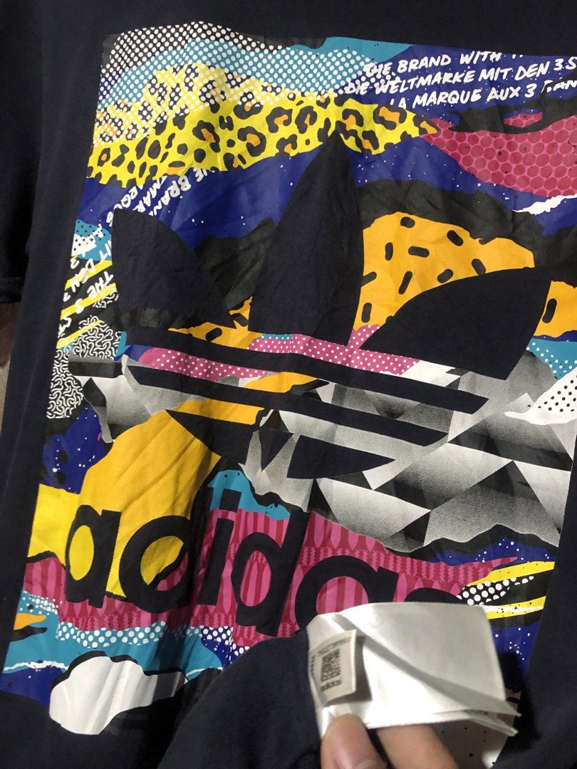 Adidas Graphic T-Shirt (Category: Tshirts & Polo Shirts ) located in Manila. Submitted by bakithrift213 (Listing ID 1463868286, Image 2). Description: - Vibrant abstract graphic print - Classic Adidas logo and three stripes on sleeves - Comfortable fabric for everyday wear - Perfect for casual outfits - Size: Medium (M).