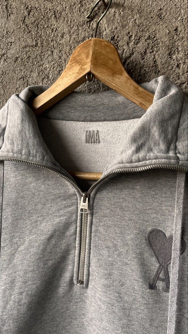 AMI Paris Grey Half Zip Sweatshirt (Category: Coats, Jackets and Outerwear) located in Cabuyao City. Submitted by bulandos (Listing ID 1463838703, Image 2). Description: - Grey AMI Paris sweatshirt - Size: S but large fittings - Signature Ami de Coeur logo embroidered on chest - Half zip closure with stand-up collar - Kangaroo pocket - Material: 100% organic cotton.