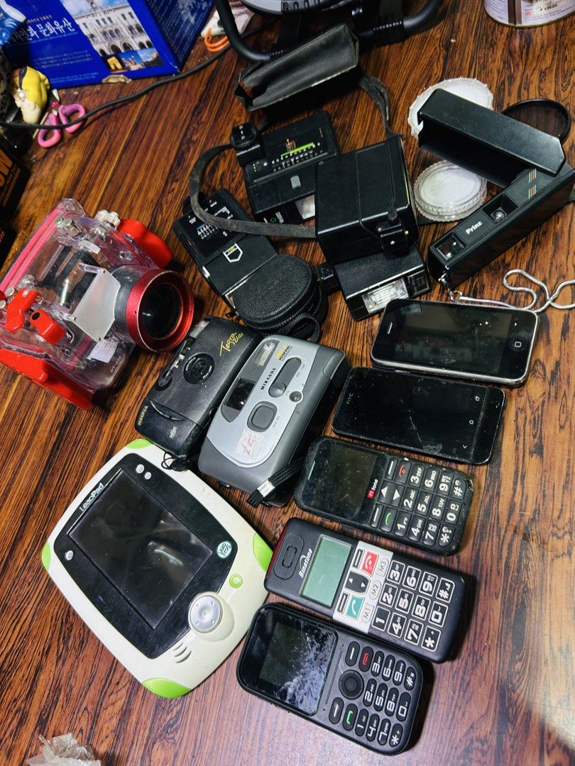 Assorted Electronics: Cameras, Phones, LeapFrog (Category: Cameras) located in Manila. Submitted by starbalesukandjapansurplus (Listing ID 1463775511, Image 1). Description: - Red underwater camera housing - Two (2) film cameras - One (1) digital camera - Camera flash - LeapFrog tablet - Several mobile phones - Ideal for collectors or for parts.