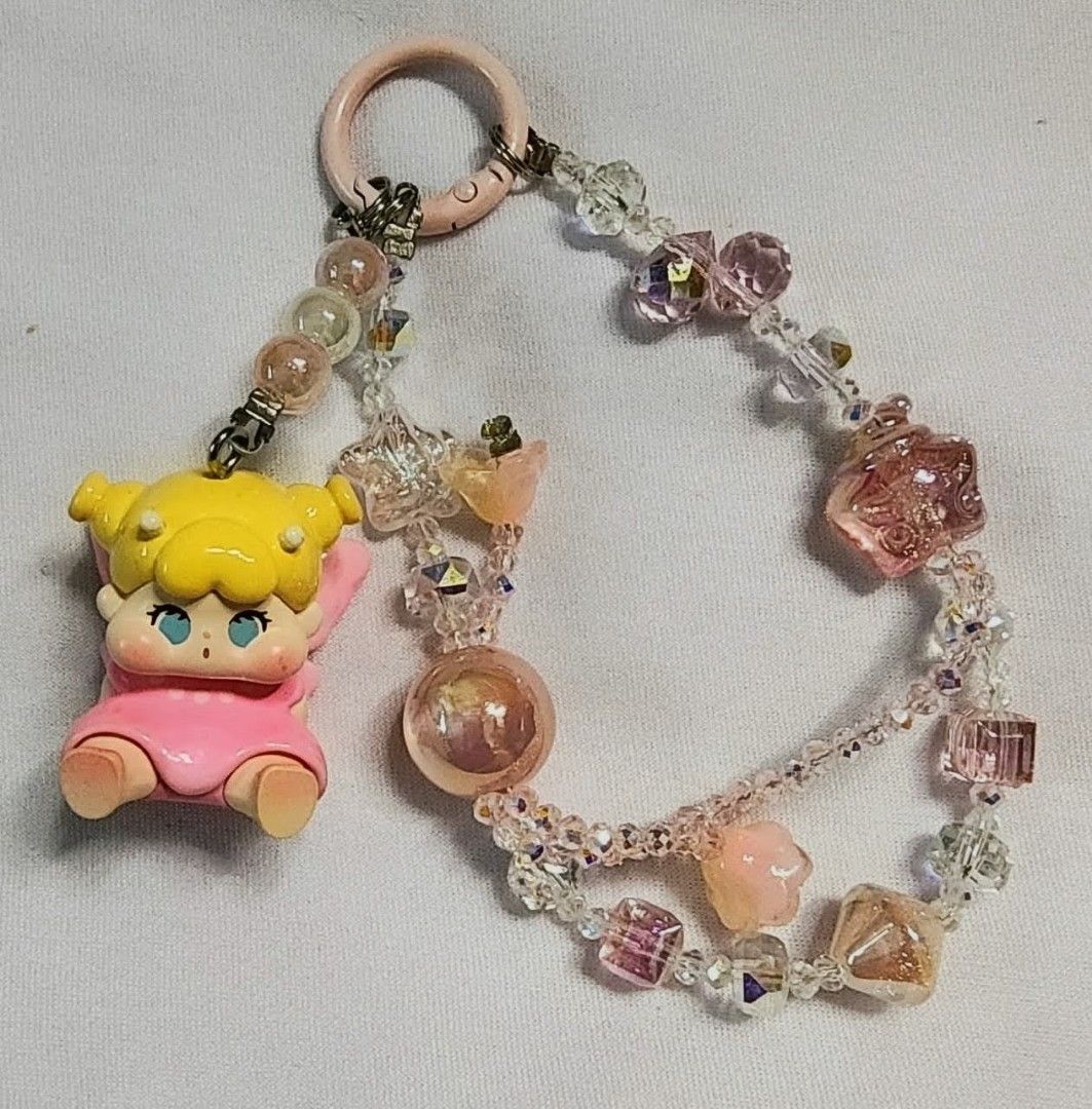 Authentic QOQO diy charms (Category: Charms) located in Caloocan City. Submitted by jark_moonshop (Listing ID 1463838548, Image 1). Description: - Adorable QOQO doll charm keychain - Adorned with sparkly pink and clear crystal beads - Features a convenient pink ring for easy attachment - Perfect for personalizing bags and keys - Unique, handmade accessory.
