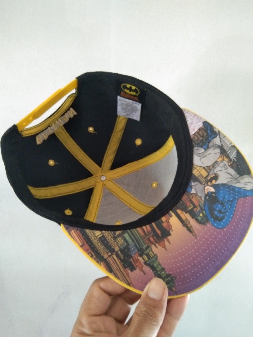 Batman Snapback Cap Black Yellow (Category: Caps & Hats) located in Manila. Submitted by tonycess16 (Listing ID 1463921544, Image 3). Description: - Cool Batman snapback cap - Black with yellow brim - Features iconic Batman logo on the front - 'BATMAN' text embroidered on the back - Adjustable strap for a comfortable fit - Unique Gotham City graphic print on the inside brim - A must-have for any Batman enthusiast.