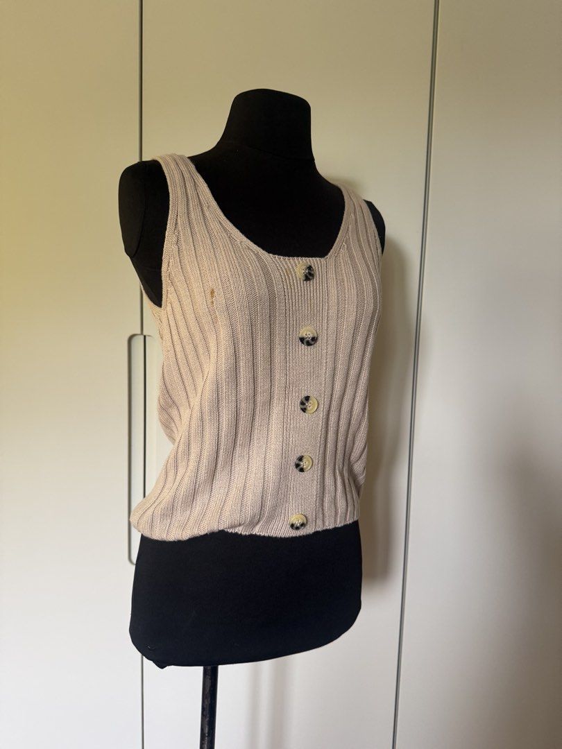 Beige Ribbed Button-Up Tank Top (Category: Sleeveless) located in Manila. Submitted by cristycrab247 (Listing ID 1463773312, Image 1). Description: - Beige ribbed tank top - Square neckline - Button details down the front - Estimated size: Small to Medium - Minor marks on front (refer to close-up photo) - Versatile for layering or wearing solo.