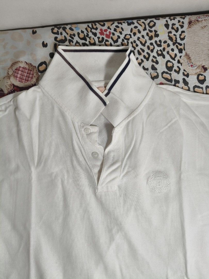 BENCH White Polo Shirt - Size XL (Category: Tshirts & Polo Shirts ) located in Lapu Lapu. Submitted by hooman422 (Listing ID 1463811607, Image 2). Description: - BENCH White Short-Sleeved Polo Shirt - Size: XL - Classic collar with striped trim - Small embroidered logo on chest - Button-up neckline - Perfect for casual outfits.