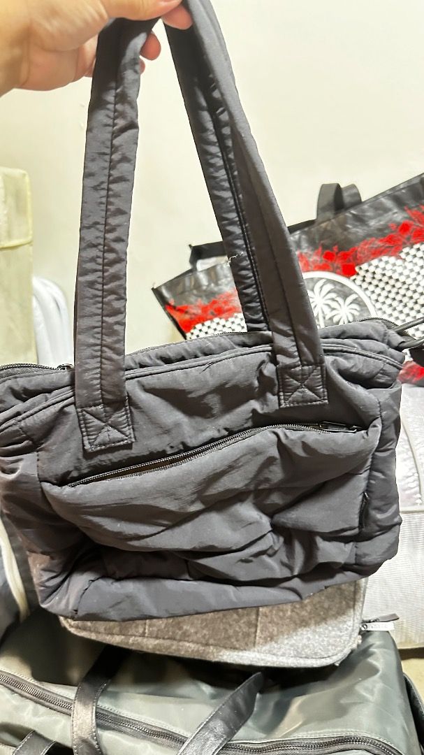 Black Puffer Tote Bag (Category: Tote Bags) located in Quezon City. Submitted by macelpain (Listing ID 1463742390, Image 1). Description: -Preloved - compartment of laptop 13inch - Stylish black puffer tote bag - Convenient zippered front pocket - Durable fabric straps - Ideal size for daily use - Spacious interior for all your essentials.