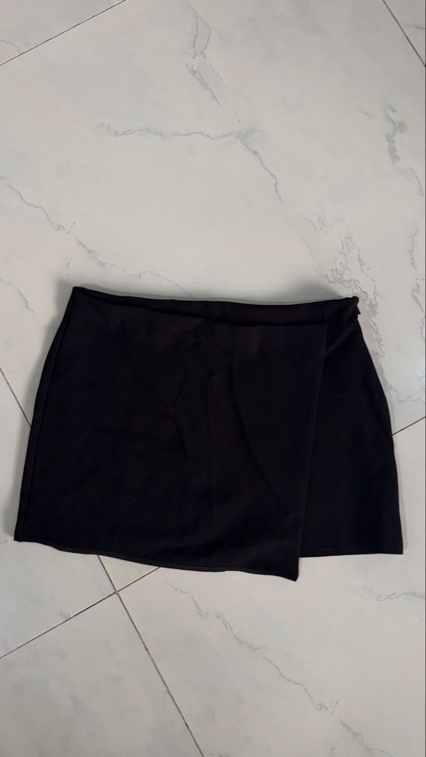 Black Wrap Mini Skirt (Category: Skirts) located in Manila. Submitted by patc20 (Listing ID 1463812755, Image 1). Description: - Stylish black wrap mini skirt - Estimated size: Small - Waist measurement: Approx. 13 inches (flat) - Length measurement: Approx. 16 inches - Comfortable material - Versatile for casual or dressy outfits.
