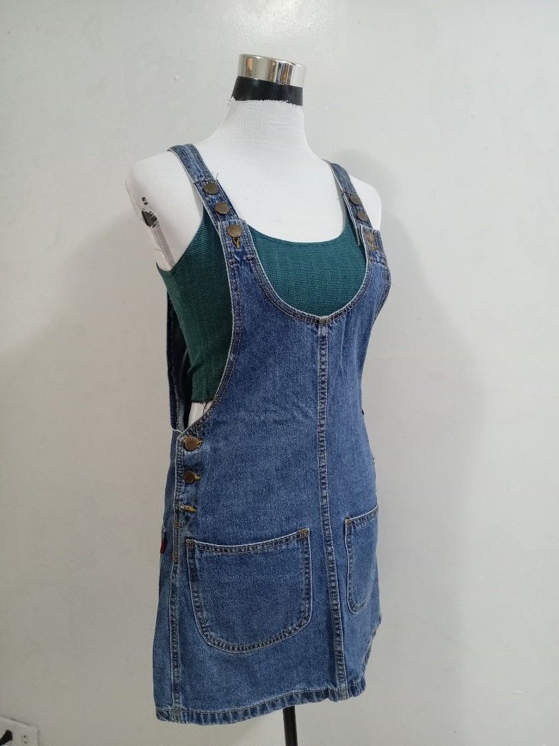 Blue Denim Pinafore romper skirt (Category: Rompers) located in Paranaque City. Submitted by janella11 (Listing ID 1463772736, Image 2). Description: - Adorable blue denim pinafore romper skirt - Features two front pockets - Button details on the side - Adjustable straps with buttons for a perfect fit - Ideal for layering over tops or tees - Effortless to wear and style for a casual look.