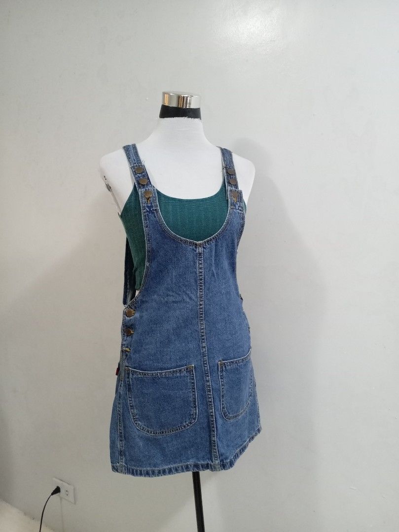 Blue Denim Pinafore romper skirt (Category: Rompers) located in Paranaque City. Submitted by janella11 (Listing ID 1463772736, Image 3). Description: - Adorable blue denim pinafore romper skirt - Features two front pockets - Button details on the side - Adjustable straps with buttons for a perfect fit - Ideal for layering over tops or tees - Effortless to wear and style for a casual look.