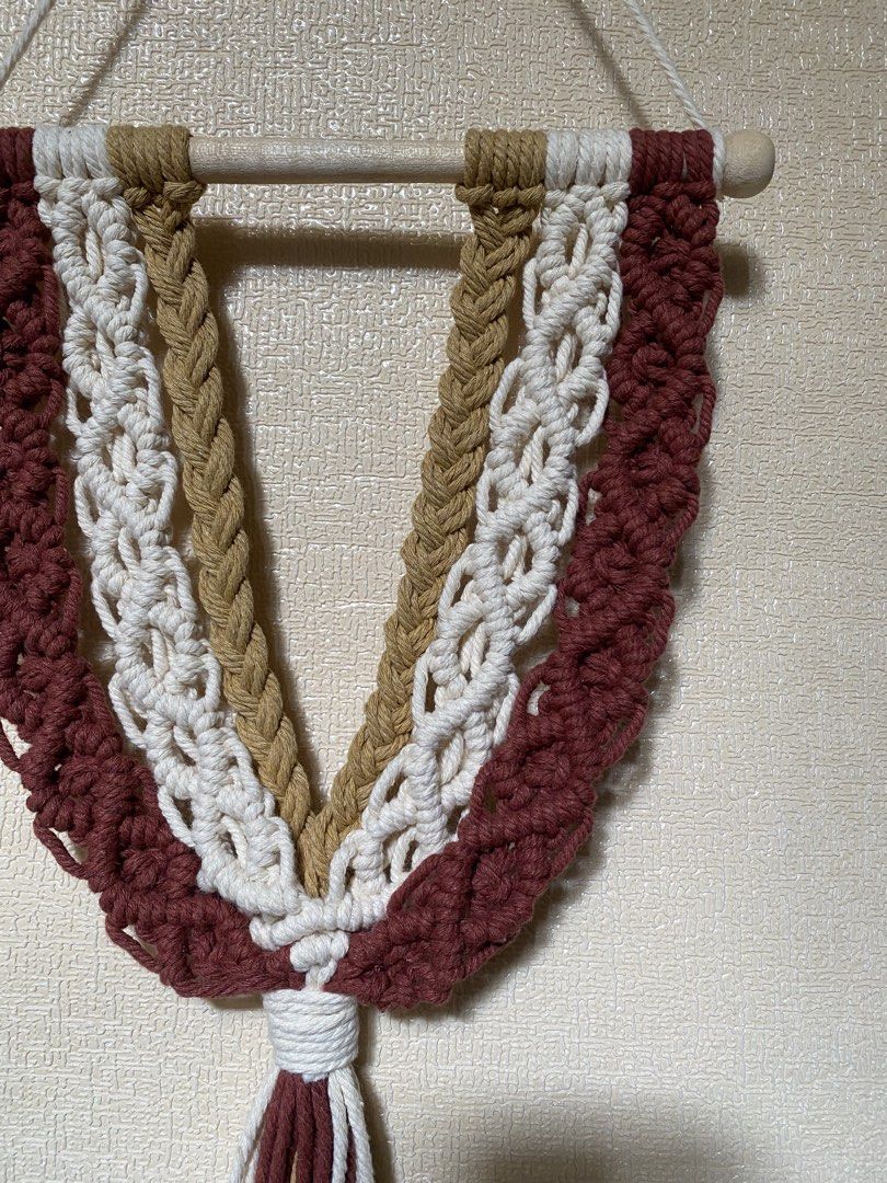 Rush SALE Boho Macrame Wall Hanging Decor (Category: Wall Decor) located in Caloocan City. Submitted by wearprelovedmnl (Listing ID 1463785117, Image 2). Description: - Handmade macrame wall hanging - Features a beautiful layered design - Colors: Maroon, white, and tan cords - Mounted on a wooden dowel - Adds a bohemian touch to any room - Perfect for living rooms, bedrooms, or nurseries - Unique home decor piece.