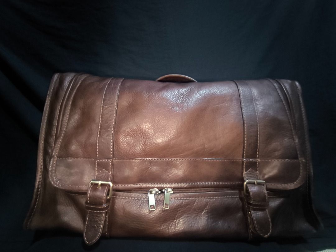 Brown Leather Messenger Bag with Buckle Straps (Category: Luxury Bags & Wallets) located in Manila. Submitted by weyvern28 (Listing ID 1463839337, Image 1). Description: - Cool brown leather messenger bag - Front buckle strap closure - Bright red fabric lining inside - Internal strap for securing items - Spacious design, perfect for carrying essentials.