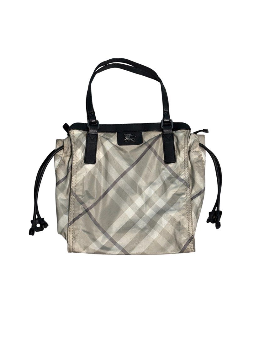 Burberry Buckleigh Nylon Tote Bag (Category: Luxury Bags & Wallets) located in Cagayan de Oro. Submitted by thatsdopethrift (Listing ID 1463878968, Image 1). Description: Authentic Burberry Buckleigh tote bag featuring the iconic mega check plaid pattern. This practical shoulder bag is crafted from lightweight, water-resistant nylon canvas with structured leather trimmings. Designed with adjustable side drawstrings to alter the bag’s silhouette a