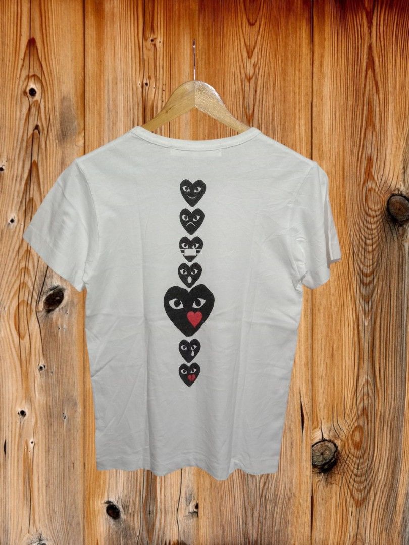 CDG Play T-shirt (Category: Tshirts & Polo Shirts ) located in Davao. Submitted by ayeeasyshop13 (Listing ID 1463905847, Image 2). Description: That's a white Play Comme des Garçons Holiday Emoji T-shirt featuring a vertical stack of black heart graphics printed down the back. As new condition Size small on tag Dimension 18/25 400 + SF.