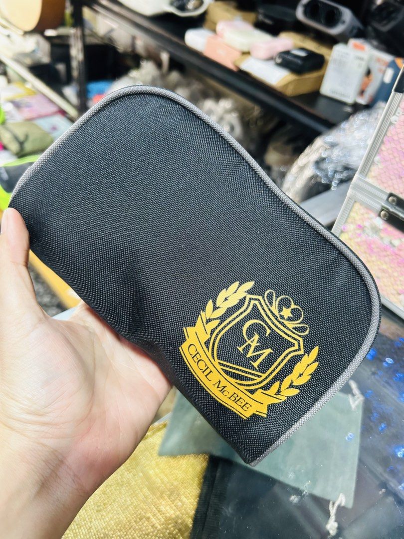 Cecil McBee Black Pouch with Gold Emblem (Category: Purses & Pouches) located in Manila. Submitted by starbalesukandjapansurplus (Listing ID 1463765955, Image 1). Description: - Black Cecil McBee pouch - Features iconic gold brand emblem on the front - Secure zipper closure with two pull tabs - Ideal for organizing small essentials like makeup or stationery - Compact and portable for on-the-go use.