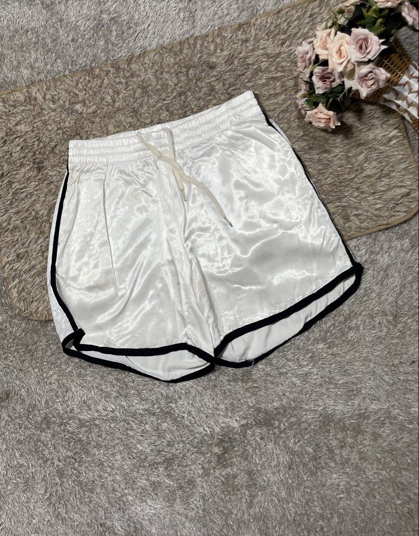Celine White Satin Shorts with Black Trim (Category: Luxury Apparel) located in Manila. Submitted by rutchemari68583 (Listing ID 1463843653, Image 1). Description: - Brand: Celine - Color: White - Material: Satin (very shiny) - Features: Elastic waistband with drawstring, black trim along sides and hem - Style: Ideal for lounging or casual wear Waistline 28-30.