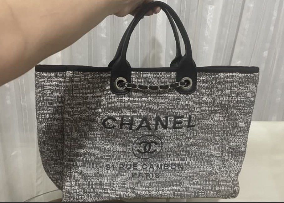 Chanel Deauville Tote Bag coded (Category: Tote Bags) located in General Trias. Submitted by csrtechsol61982 (Listing ID 1463879943, Image 1). Description: - Classic Chanel tote bag - Iconic Chanel logo and "31 RUE CAMBON PARIS" print - Textured woven exterior - Luxurious leather handles - Elegant chain accents - Spacious interior for essentials - Stylish everyday bag.