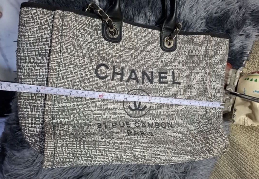 Chanel Deauville Tote Bag coded (Category: Tote Bags) located in General Trias. Submitted by csrtechsol61982 (Listing ID 1463879943, Image 3). Description: - Classic Chanel tote bag - Iconic Chanel logo and "31 RUE CAMBON PARIS" print - Textured woven exterior - Luxurious leather handles - Elegant chain accents - Spacious interior for essentials - Stylish everyday bag.