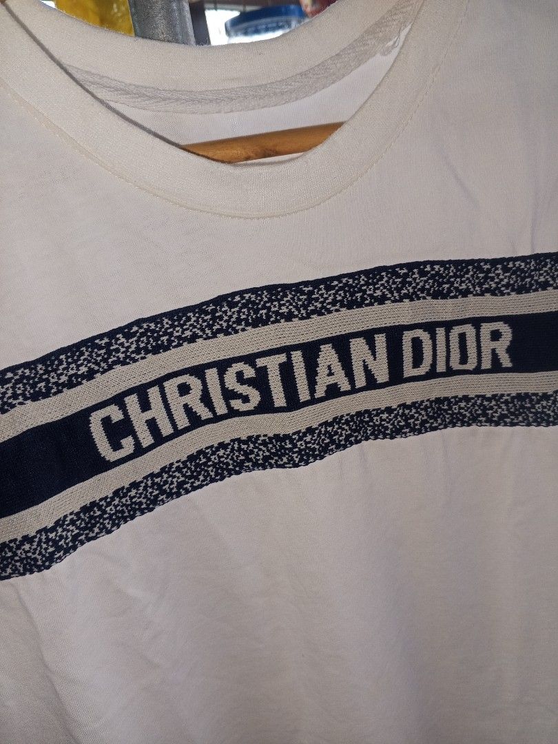 Christian Dior T-shirt White (Category: Luxury Apparel) located in Magalang. Submitted by zeiansoria64090 (Listing ID 1463758631, Image 2). Description: - Christian Dior white t-shirt - Size: Medium (M) - Features classic Dior stripe across the chest with brand name - Material: 100% Cotton - Ideal for casual wear.