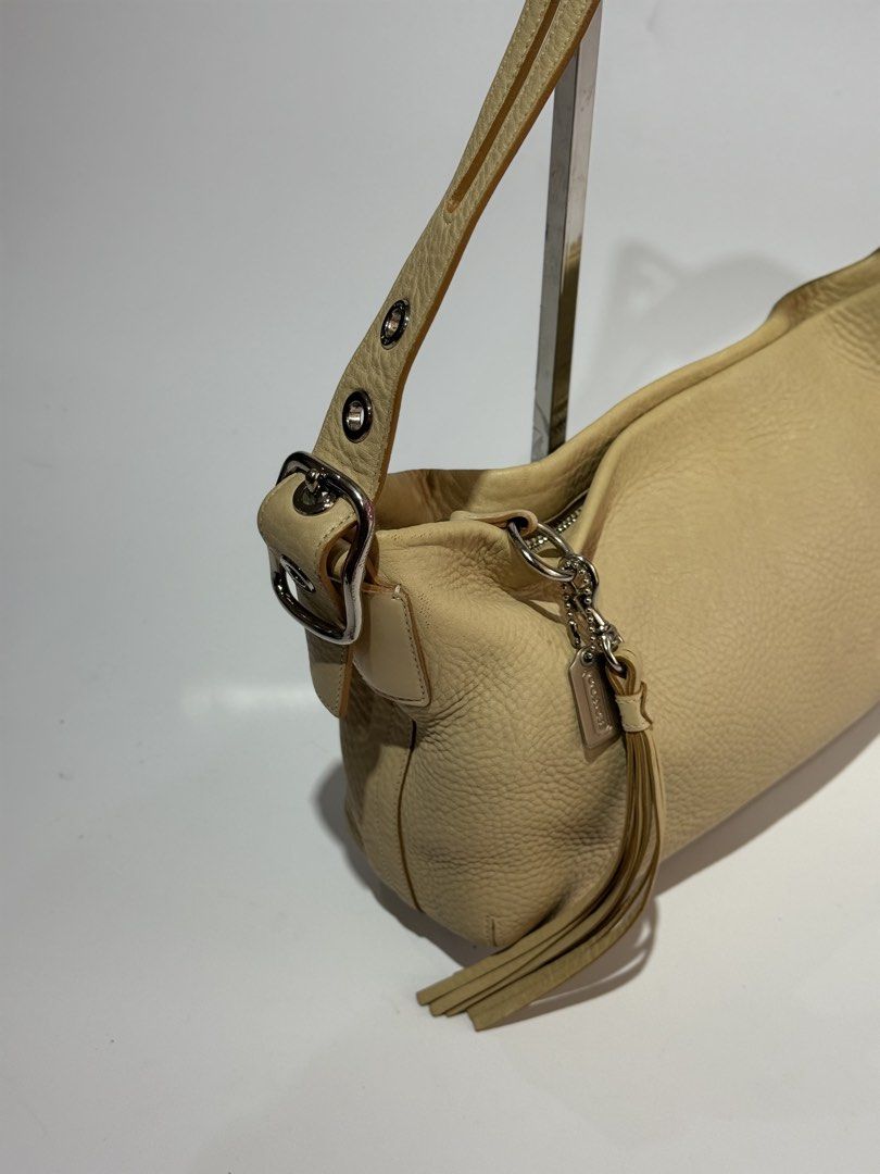 Coach Leather Hobo Shoulder Bag Beige (Category: Luxury Bags & Wallets) located in Manila. Submitted by eddjohn (Listing ID 1463891957, Image 3). Description: - Coach hobo bag - Light beige pebbled leather - Silver hardware - Tassel detail - Adjustable shoulder strap with buckle - Spacious interior - Classic Coach design.