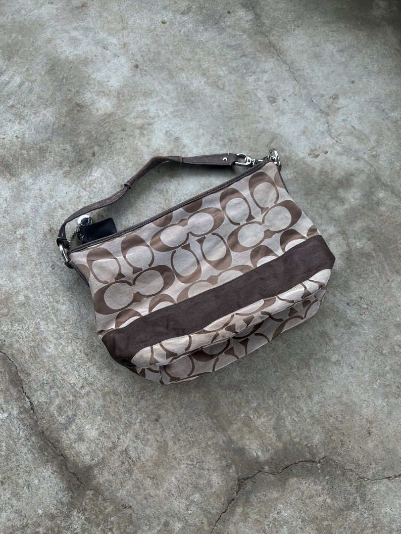 Coach Monogram Canvas Shoulder Bag (Category: Luxury Bags & Wallets) located in M'Lang. Submitted by alexpabillo0324 (Listing ID 1463757317, Image 1). Description: - Classic Coach monogram shoulder bag - Color: Brown and tan signature 'C' pattern - Material: Leather trim and strap - Closure: Zipper - Interior: Includes leather tag with serial number - Condition: Some wear on leather strap and trim - Perfect for everyday use.